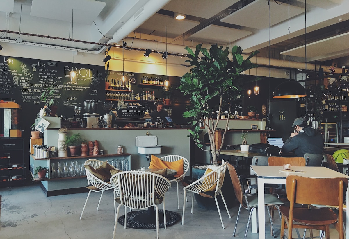 A coffeeshop counter at closing time with stools stacked